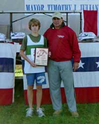 Image of Chris Buchanan (Cicero-North Syracuse) receives the Ralph Lupia Award for the fastest junior high male runner from Mr. Ralph Lupia